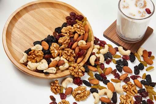 Mix of dried nuts and raisins isolated on a white background.