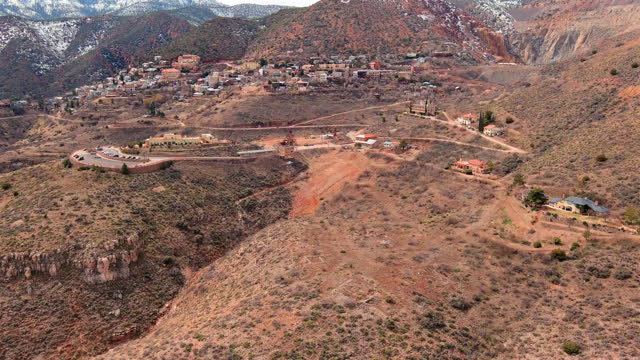 Establishing shot of Jerome, Arizona. Aerial reveal from behind high desert hill