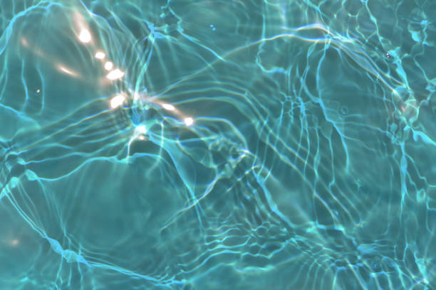 istock Blue water with ripples on the surface. Defocus blurred transparent blue colored clear calm water surface texture with splashes and bubbles. Water waves with shining pattern texture background. 1679582011