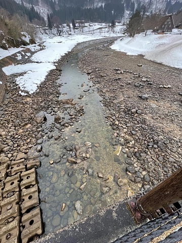 a photography of a river running through a rocky valley, lumbermill creek in the mountains with a stream running through it.