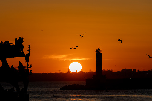 Istanbul cityscape with lighthouse at sunset.