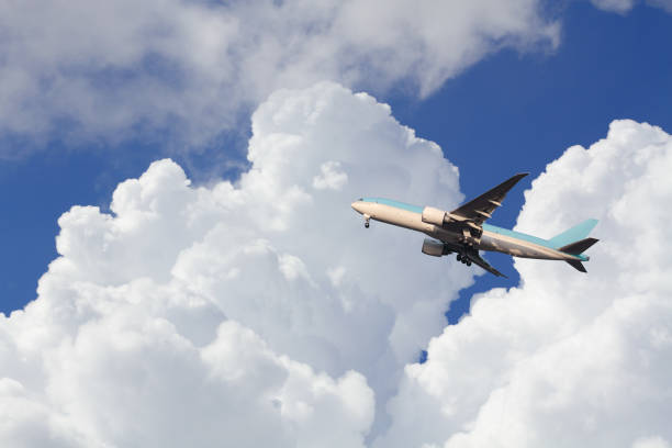 istock Airplane taking off across a blue sky with dramatic cumulus clouds. 1679629112