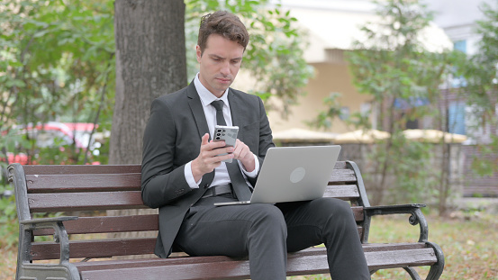 Young Businessman Working on Laptop and Smartphone