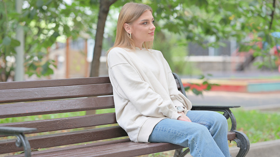 Young Woman Coming and Sitting on Bench