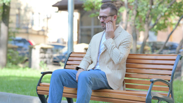 istock Middle Aged Man with Toothache Sitting Outdoor 1679669141