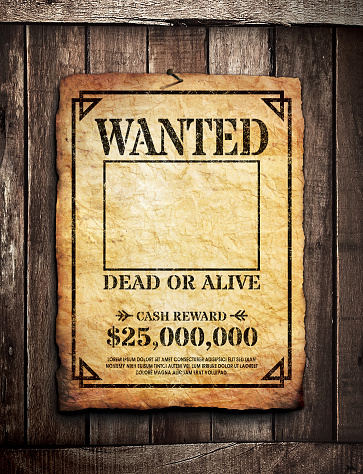 Wanted poster tacked on wooden surface