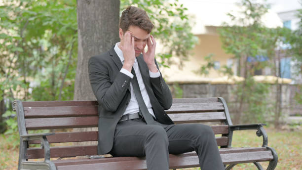 istock Young Businessman Sitting Outdoor with Headache 1679707825