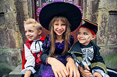 Happy kids sitting by the door on Halloween
