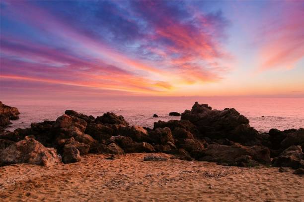istock sunset at the beach with rocks 1679719474