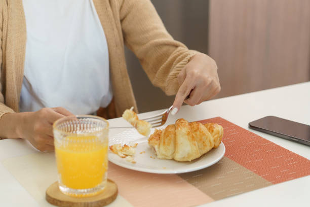 istock Happy woman having breakfast crispy croissants 1679739121