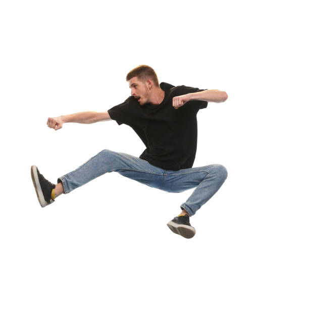 istock Overcoming difficulties. Young man jumping in fighting pose isolated on white background 1679743859