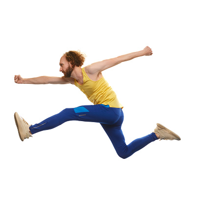 Young man in sportswear running in a jump isolated on white background. Overcoming difficulties. Motivation. Concept of youth, active lifestyle, motivation, emotions and facial expression. Ad