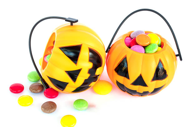 istock Halloween pumpkin face buckets with colorful candy inside isolated over white 1679775130