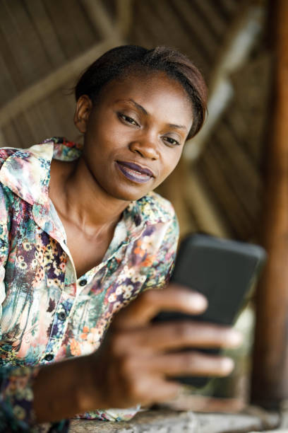 istock Smiling black woman using mobile phone on a terrace. 1679779563