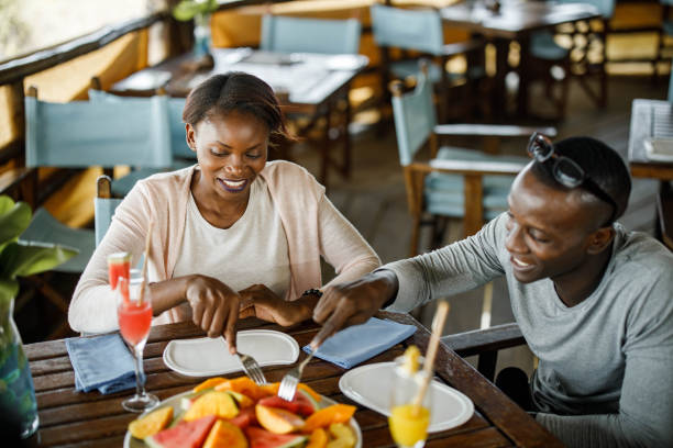 Happy black couple enjoying in snack time in a restaurant.