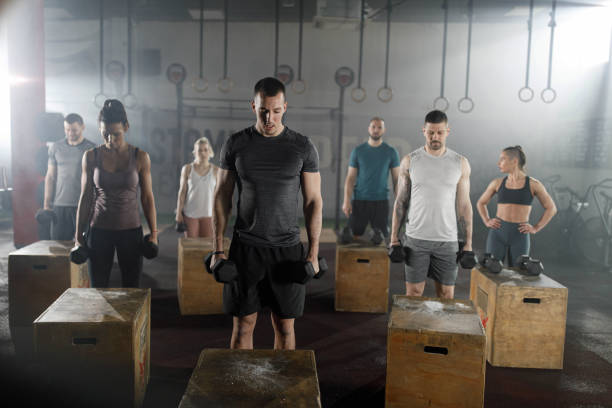 istock Athletic people preparing for cross training with dumbbells in a gym. 1679787589