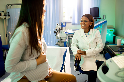 Young pregnant woman having a medical consultation with a female gynecologist