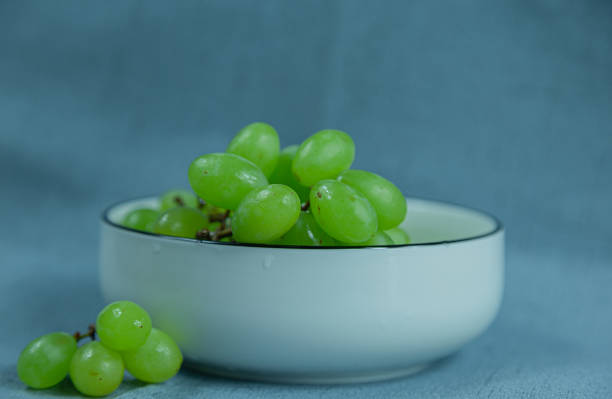 Fresh green grapes in a white porcelain bowl