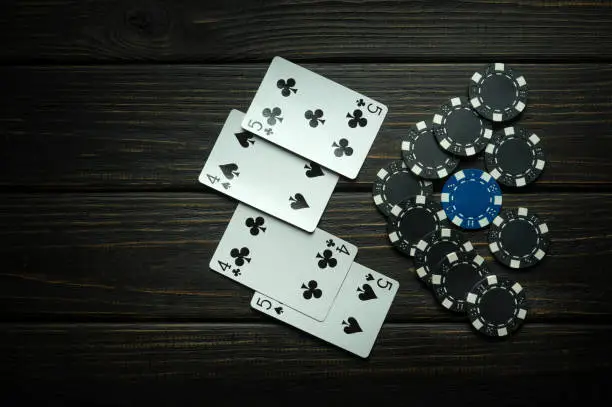 Photo of A popular poker game with a combination of two pairs. Chips and cards on a black vintage table in a poker club. Free space for advertising