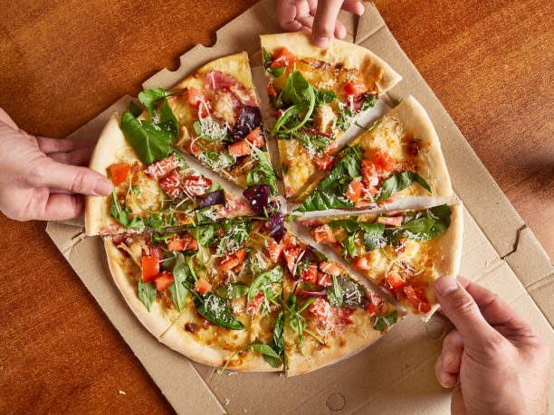 istock People enjoy pizza, each taking a piece. View from above. 1679836890
