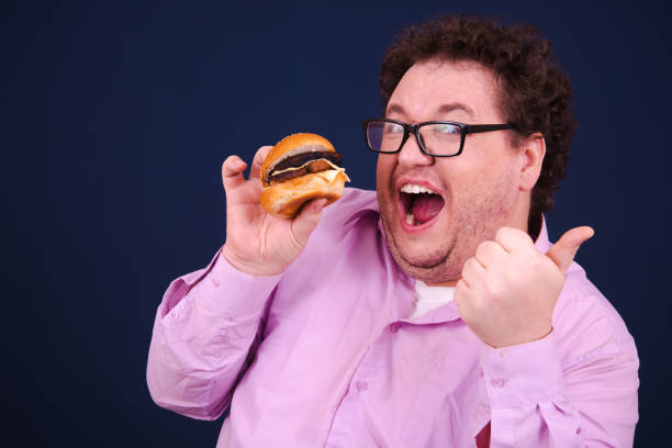 istock Funny hungry fat man eating burger. 1679842916