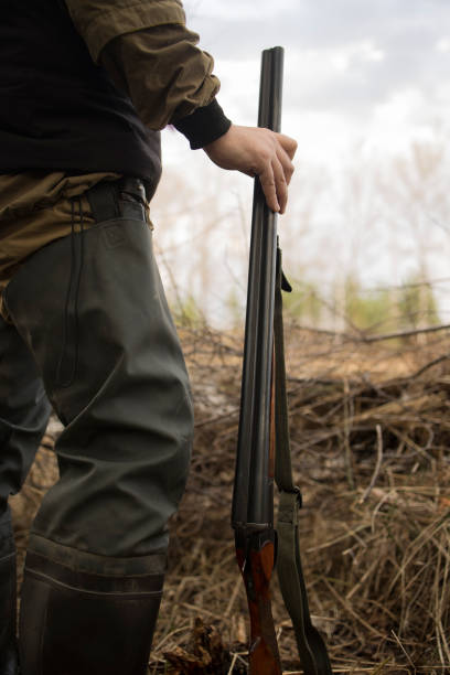 istock Hunter man hunts with a gun for ducks on the river bank 1679858960