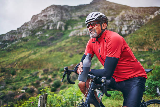 Fitness, cycling and water with man on bike in nature for sports, training and challenge. Exercise, workout and health with mature person on bicycle in mountains for energy, freedom and performance fitness, ciclismo y agua con el hombre en bicicleta en la naturaleza para deportes, entrenamiento y desafío. ejercicio, entrenamiento y salud con una persona madura en bicicleta en las montañas para obtener energía, libertad y rendimiento