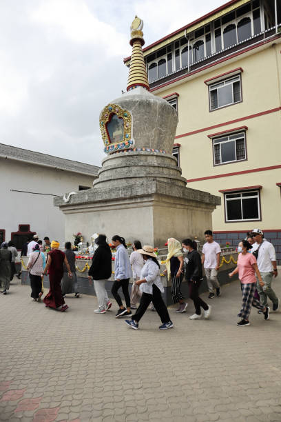 un gruppo di fedeli tibetani circonda il sacro stupa con reliquie del signore buddha nel monastero del tempio d'oro di bylakuppe nel karnataka, in india. - indian ethnicity traditional culture architecture karnataka foto e immagini stock