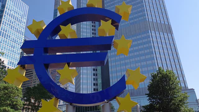 Euro sign sculpture by German artist Ottmar Hoerl, stands in front of the Eurotower of the European Central Bank.