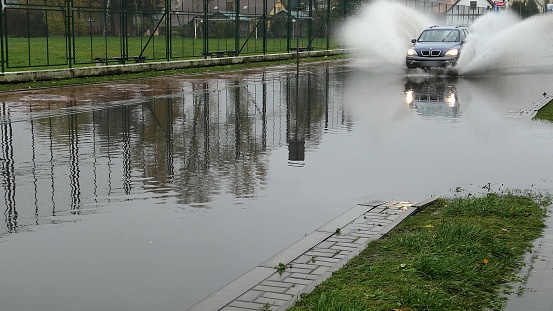 Cars Crossing Flooded Urban Street