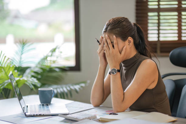 istock Young Asian businesswoman working on laptop computer, stressed has a headache and thinks hard from work at the office. 1679942778