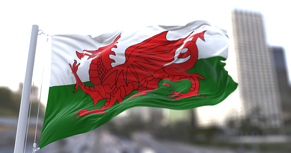 3d illustration flag of Wales. Wales flag isolated on the sky waving in the wind.