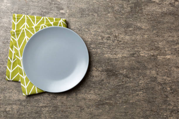 istock Top view on colored background empty round gray plate on tablecloth for food. Empty dish on napkin with space for your design 1679963685