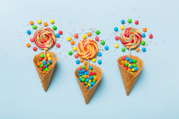 istock waffle cone full of assorted traditional candies falling out on colored background with copy space. Happy Holidays sale concept 1679964646