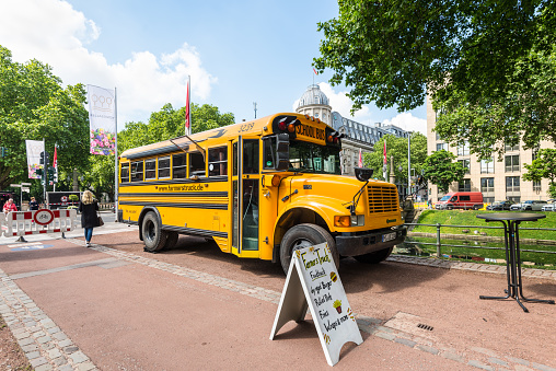 Dusseldorf, Germany - June 2, 2022: An American style yellow school bus is used as a food truck at the popular tourist attraction in the center of Dusseldorfs, North Rhine-Westphalia, Germany.