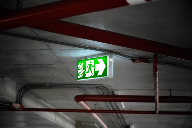 istock Fire exit sign or emergency singn, light in the dark on the parking lot in the building, exit singn in the dark light, close-up sing. 1680017288