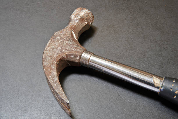 istock nail hammer head on black wooden table 1680021640