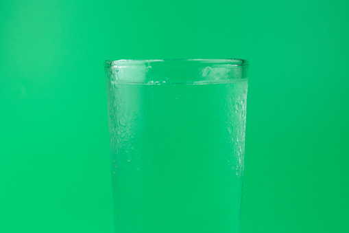 Punch on the rocks in drinking glass decorated with mint leaf and orange peal, outdoor bar