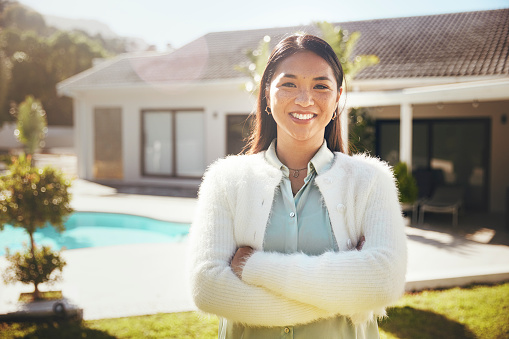 In this picturesque scene, a stunning woman, her freckles adding character to her beauty, taking center stage. Behind her, a tranquil autumn garden is awash in the warm hues of the season. Adjacent to the garden is a glistening pool, adding a touch of luxury, and a magnificent house completes this idyllic setting.