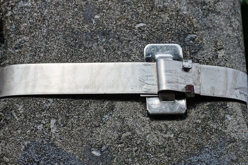 one long white metal plate snap mount on a gray concrete pole on the street