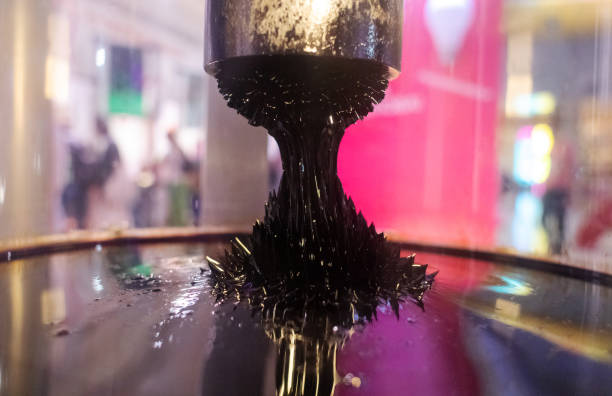 Ferromagnetic fluid. Metal shavings in a dark liquid under the influence of a neodymium magnet are stretched and become like tentacles. Alien technology concept. Protruding peaks. Protruding peaks. Ferromagnetic fluid. Metal shavings in a dark liquid under the influence of a neodymium magnet are stretched and become like tentacles. Alien technology concept. scientific experiment magnetic field ferro ferrofluid stock pictures, royalty-free photos & images