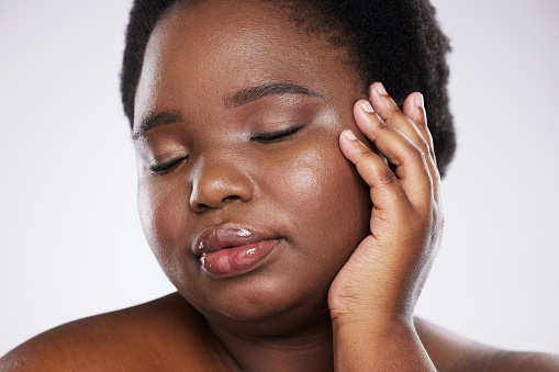 Makeup, beauty and young black woman with hands and face zoom for spa and skincare aesthetic. White background, isolated and studio model with skin glow from dermatology and facial wellness results