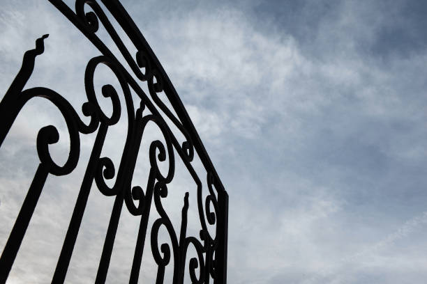 Wrought iron gate and cloudy sky on background