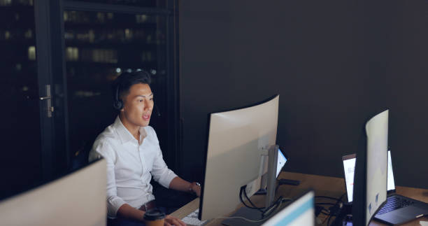 istock Call center, agent and man, crm and contact us, phone call with night work and communication, pc and headset. Telemarketing, customer service or tech support, talk to client and Asian agent help desk 1680095808