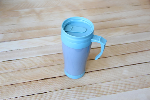 Blue thermo mug on a wooden background