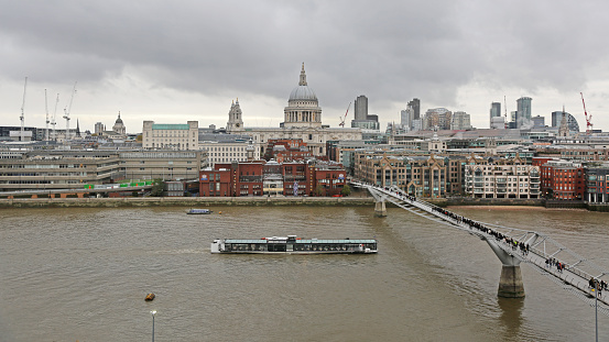 London, United Kingdom - November 24, 2013: Tourist Boat Pass Under Millennium Bridge at Thames River in Capital City Cloudy Winter Day.