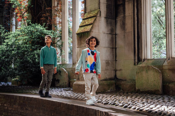 Two young boys explore the ruins of a building