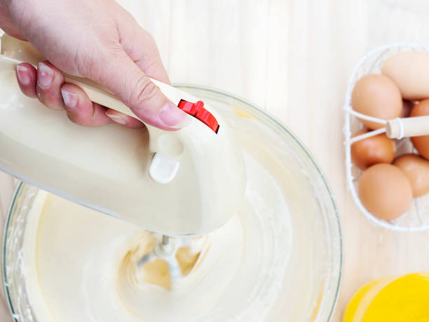 istock Toy view of lady's hand preparing cake using hand mixing machine with egg and butter 1680177804