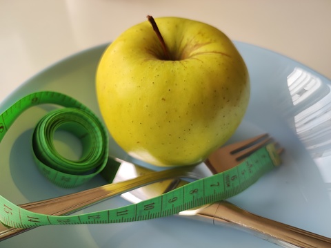 Apple and measuring tape, knife and fork