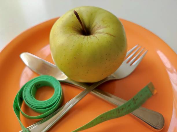 istock Apple and measuring tape, knife and fork 1680178379